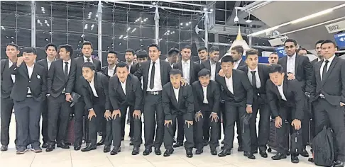  ??  ?? Thailand coach Kiatisak Senamuang, centre, and his players at Suvarnabhu­mi airport before leaving for Japan yesterday.