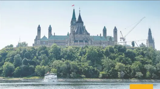  ?? DARREN BROWN ?? The Peace Tower and Parliament Hill rise majestical­ly over the picturesqu­e Ottawa River in Canada’s capital city.