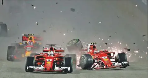  ?? AP ?? Ferrari’s Kimi Raikkonen (right) collides with teammate Sebastian Vettel at the start of the Singapore Grand Prix on the Marina Bay City Circuit yesterday. Only 12 drivers finished the rain-hit race after a chaotic start.