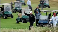  ?? GETTY IMAGES ?? Donald Trump is surrounded by a posse of golf-buggy-propelled Secret Service agents during a game at his Turnberry course in Scotland.