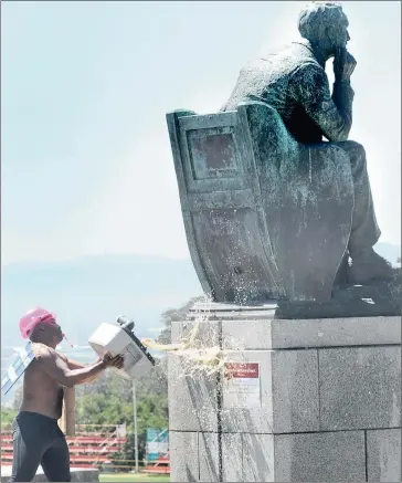  ?? Picture: BRENTON GEACH ?? CAUSING A STINK: UCT student Chumani Maxwele throws human excrement at the statue of Cecil John Rhodes on the campus rugby field. He said black students were offended by the colonial atmosphere at UCT.