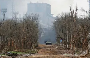  ?? (Alexander Ermochenko/Reuters) ?? AN ARMORED vehicle belonging to pro-Russian troops drivers along a street near a plant of Azovstal Iron and Steel Works company in the southern port city of Mariupol, Ukraine last year.