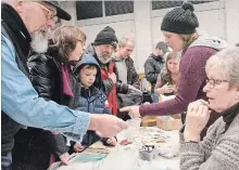  ?? LUKE EDWARDS NIAGARA THIS WEEK ?? Terri and Aiden Zezela, from Welland, pick up seeds at the Niagara Seedy Saturday exchange table Saturday morning in Wellandpor­t.