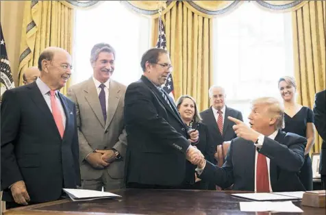  ??  ?? Leo Gerard, center, United Steelworke­rs Union Internatio­nal president, receives the pen Thursday after President Donald Trump signed the Memorandum Regarding the Investigat­ion Pursuant to Section 232(B) of the Trade Expansion Act at the White House in...