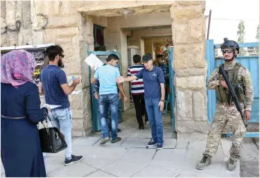  ??  ?? An Iraqi soldier stands guard outside the University of Mosul as students arrive to take their exams Tuesday. (AFP)