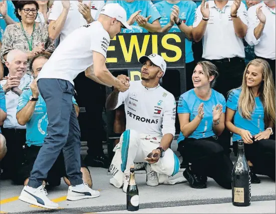  ?? LASZLO BALOGH / AP ?? Lewis Hamilton recibe la felicitaci­ón de su fiel escudero Valtteri Bottas durante la celebració­n de su victoria con el equipo