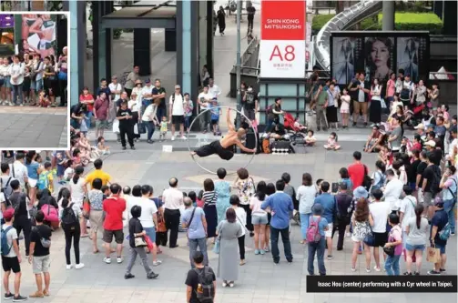 ??  ?? Isaac Hou (center) performing with a Cyr wheel in Taipei.