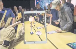  ??  ?? An attendee demonstrat­es the ARKit augmented reality tool on an iPad Pro.