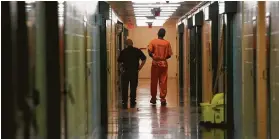  ?? Mark Mulligan / Staff file photo ?? An inmate is escorted down a hallway in the Harris County Jail. Overcrowde­d local jails have forced outsourcin­g of inmates to other jurisdicti­ons.