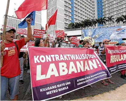  ?? —RICHARD A. REYES ?? WORKERS’ PROTEST Members of labor groups condemn President Duterte’s not issuing an executive order to end contractua­lization during a Black Friday protest at Mabuhay Rotunda in Quezon City on April 20.