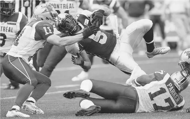  ?? JOHN WOODS/ THE CANADIAN PRESS ?? The Bombers’ Chad Simpson is taken down by the Alouettes’ Billy Parker and Chip Cox in the first half Thursday. The Als took the season opener 38-33.