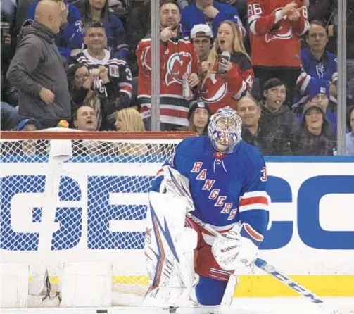  ?? AP ?? Devils fans and Rangers goaltender Igor Shesterkin react after John Hayden scored during the second period on Saturday at the Garden.