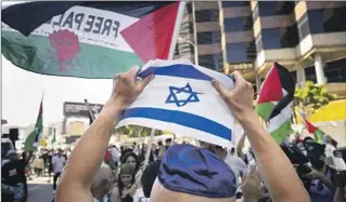  ?? Jay L. Clendenin Los Angeles Times ?? AT THE Israeli Consulate in L.A. last week, a supporter of Israel faces pro-Palestinia­n protesters.