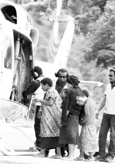  ?? — AFP photo ?? This handout photo shows locals boarding a helicopter for a flight back to their village from the company’s medical centre at Moro in Papua New Guinea.