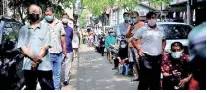  ??  ?? Residents wearing face masks line up for nucleic acid testings at a residentia­l compound in Wuhan