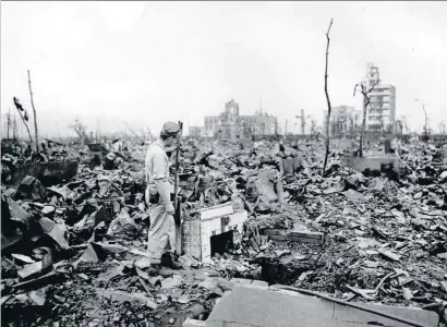  ?? STANLEY TROUTMAN / AP ?? Un hombre observa lo que queda de una chimenea en Hiroshima, en septiembre de 1945