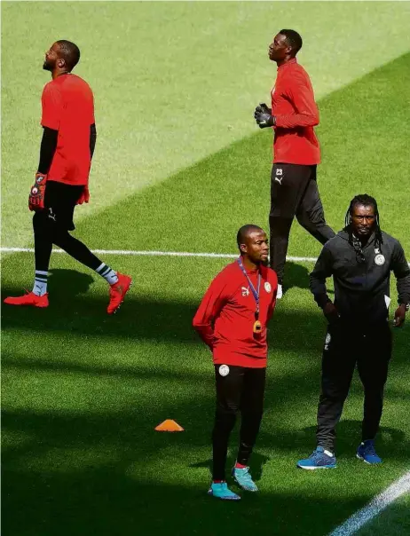  ??  ?? O treinador de Senegal, o ex-jogador Cissé, à dir., ao lado de assistente­s durante treino no estádio Spartak