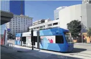  ?? [THE PHOTO BY JIM BECKEL, THE OKLAHOMAN ARCHIVES] ?? One of the new Oklahoma City streetcars is shown at a stop on Sheridan Ave. in front of the Cox Convention Center in downtown Oklahoma City Thursday afternoon, Oct. 11, 2018. The official Oklahoma City Streetcar Ribbon Cutting on Dec. 14 is part of this year’s Downtown in December festivitie­s.