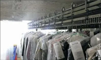  ?? The Sentinel-Record/Max Bryan ?? WINDING DOWN: One of the Speed Check garment conveyors used at ABC Cleaners is loaded with clothing ready to be picked up. The dry-cleaning business is closing down today after almost 60 years in operation.