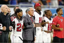  ?? PHOTO BY LEON HALIP / GETTY IMAGES ?? Atlanta Falcons owner Arthur Blank joins arms with his players during the playing of the national anthem before the game against the Detroit Lions at Ford Field on Sunday in Detroit.