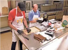  ?? CLYDE MUELLER/THE NEW MEXICAN ?? The Santa Fe Community Convention Center community kitchen is open downtown, allowing vendors Paul Bitts, left, and Ricardo Perez to prepare burritos.