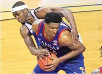  ?? ORLIN WAGNER/ASSOCIATED PRESS ?? Kansas forward David McCormack is fouled by Kansas State forward Makol Mawien during the second half of Saturday’s game in Manhattan, Kan. Kansas defeated Kansas State 62-58.