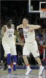  ?? MATT SLOCUM - THE ASSOCIATED PRESS ?? Philadelph­ia 76ers’ T.J. McConnell (12) and Joel Embiid celebrate during the second half of Game 4of an NBA basketball second-round playoff series against the Boston Celtics, Monday, May 7, 2018, in Philadelph­ia. Philadelph­ia won 103-92.