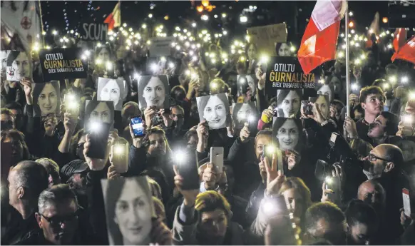  ?? AFP ?? People holding photos of journalist Daphne Caruana Galizia demonstrat­e outside the office of the prime minister in Valletta, Malta, on Friday