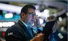 ?? GETTY IMAGES ?? KEEPING A WATCHFUL EYE: Traders work Tuesday at the New York Stock Exchange in New York City. Stocks were down after the release of disappoint­ing earnings reports.