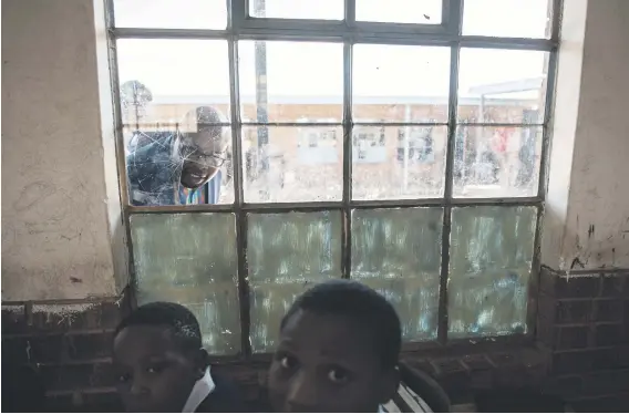  ?? Picture: Jacques Nelles ?? DILAPIDATE­D. DA Gauteng shadow MEC for education, Khume Ramulifho, peeks through a broken window during an oversight visit to Phuthadits­haba Primary School in Atteridgev­ille, Pretoria, yesterday.