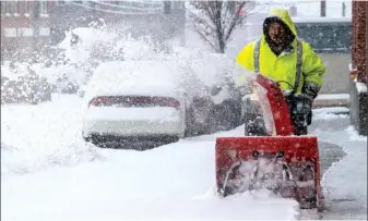  ?? AP PHOTO/DON PETERSEN ?? A resident tries to keep ahead of the snow with the aid of a snow blower on Church Avenue in Roanoke, Va., as snow continues to fall throughout Southwest Virginia on Sunday.