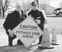  ?? ALEX PEDERSEN SPECIAL TO THE ST. CATHARINES STANDARD ?? Peter Van Hezewyk, CAA Niagara president and CEO, and Romolo Di Egidio, Niagara Regional Police staff sergeant, kneel beside a pothole.