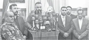  ?? — Reuters photo ?? A spokesman for the Fateh coalition delivers a statement at the home of Iran’s consul-general in Najaf.