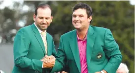  ?? GETTY IMAGES ?? Masters champion Patrick Reed ( right) is congratula­ted by 2017 winner Sergio Garcia after being presented with the green jacket Sunday at Augusta National.