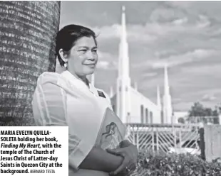  ?? Bernard Testa ?? Maria Evelyn Quillasole­ta holding her book, Finding My heart, with the temple of the Church of Jesus Christ of latter-day saints in Quezon City at the background.