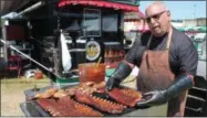  ?? LAUREN HALLIGAN - MEDIANEWS GROUP ?? Bob Santorelli of the Altamont-based Corner Grill BBQ makes ribs on Sunday at the sixth annual Saratoga Balloon and BBQ Festival at the Saratoga County Fairground­s in Ballston Spa.