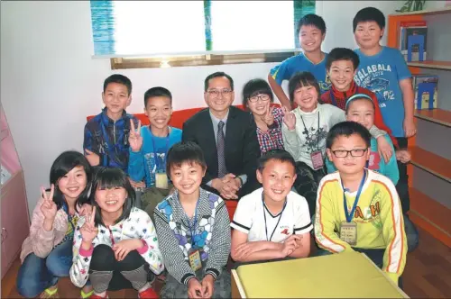  ?? PROVIDED TO CHINA DAILY ?? Leung Wai-ming sits with students from Yintang Village Middle School, Shuangfeng county, Hunan province. The school is one of 300 in the province that have received books donated by the Reading Dream Program, which Leung launched in 2007.