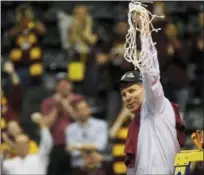  ?? MIKE STEWART — THE ASSOCIATED PRESS ?? Loyola-Chicago head coach Porter Moser holds the net after regional victory over Kansas State.