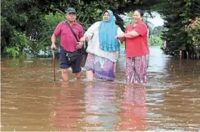  ?? ?? Deep waters: villagers leaving home as flash floods hit Kampung Johan Setia in Klang following continuous rain. — KK Sham/the Star