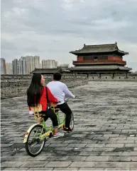  ??  ?? Des touristes sillonnent la cité ancestrale de Datong (province du Shanxi) en tandem, le 14 septembre 2018.