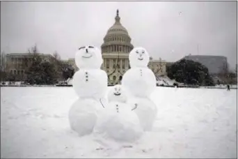  ?? ALEX BRANDON — THE ASSOCIATED PRESS ?? A snow family is seen on Capitol Hill as a winter storm arrives in the region, Sunday in Washington.