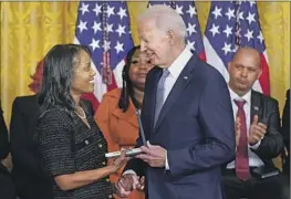  ?? Patrick Semansky Associated Press ?? PRESIDENT BIDEN presents Serena Liebengood a posthumous medal for her late husband, Officer Howard Liebengood, at the White House’s Jan. 6 event.