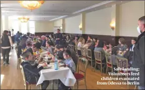  ?? ?? Safe landing: Volunteers feed children evacuated from Odessa to Berlin