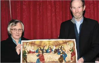  ??  ?? Dora O’Sullivan accepts a presentati­on from parish priest Fr, Gerard Coleman to mark her retirement as sacristan of the local Sts. Peter &amp; Paul’s Church at a function in the village community hall.