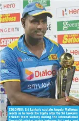 ??  ?? COLOMBO: Sri Lanka’s captain Angelo Mathews reacts as he holds the trophy after the Sri Lankan’s cricket team victory during the internatio­nal Twenty20 cricket match between Sri Lanka and South Africa at the R.Peremadasa Stadium in Colombo yesterday. — AFP
