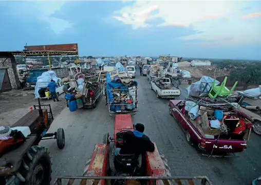  ?? AP ?? Truckloads of civilians flee a Syrian military offensive in Idlib province on the main road near Hazano, Syria.