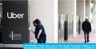  ??  ?? SAN FRANCISCO: A worker cleans a sign in front of the Uber headquarte­rs on Monday in San Francisco, California. Uber announced plans to cut 3,000 jobs and shutter or consolidat­e 40 offices around the world due to severely declining business as the coronaviru­s (COVID-19) pandemic continues. – AFP