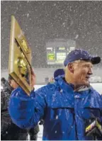  ?? STAFF PHOTO BY TIM BARBER ?? Red Bank football coach Tom Weathers holds his team’s first-place plaque prior to the presentati­on of the state championsh­ip trophy after the Lions beat Riverdale to win the TSSAA Class 5A title in 2000.