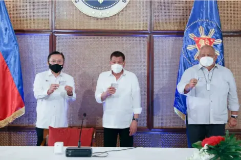  ?? PHOTOGRAPH COURTESY OF MALACAÑANG ?? PRESIDENT Rodrigo Duterte (center), Senator Christophe­r Lawrence ‘Bong’ Go (left) and Executive Secretary Salvador Medialdea were issued their national identifica­tion cards in a ceremony. The proposed ID scheme is expected ease delivery of services, enhance governance, reduce corruption, curtail red tape, promote ease of doing business, and strengthen financial inclusion.