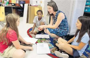  ?? AMY BETH BENNETT/STAFF PHOTOGRAPH­ER ?? Kathleen Mitchell works with fifth-graders at Hidden Oaks Elementary in Boynton Beach. Hidden Oaks will transition into a K-8 school, starting by adding sixth grade for the 2017-2018 school year.